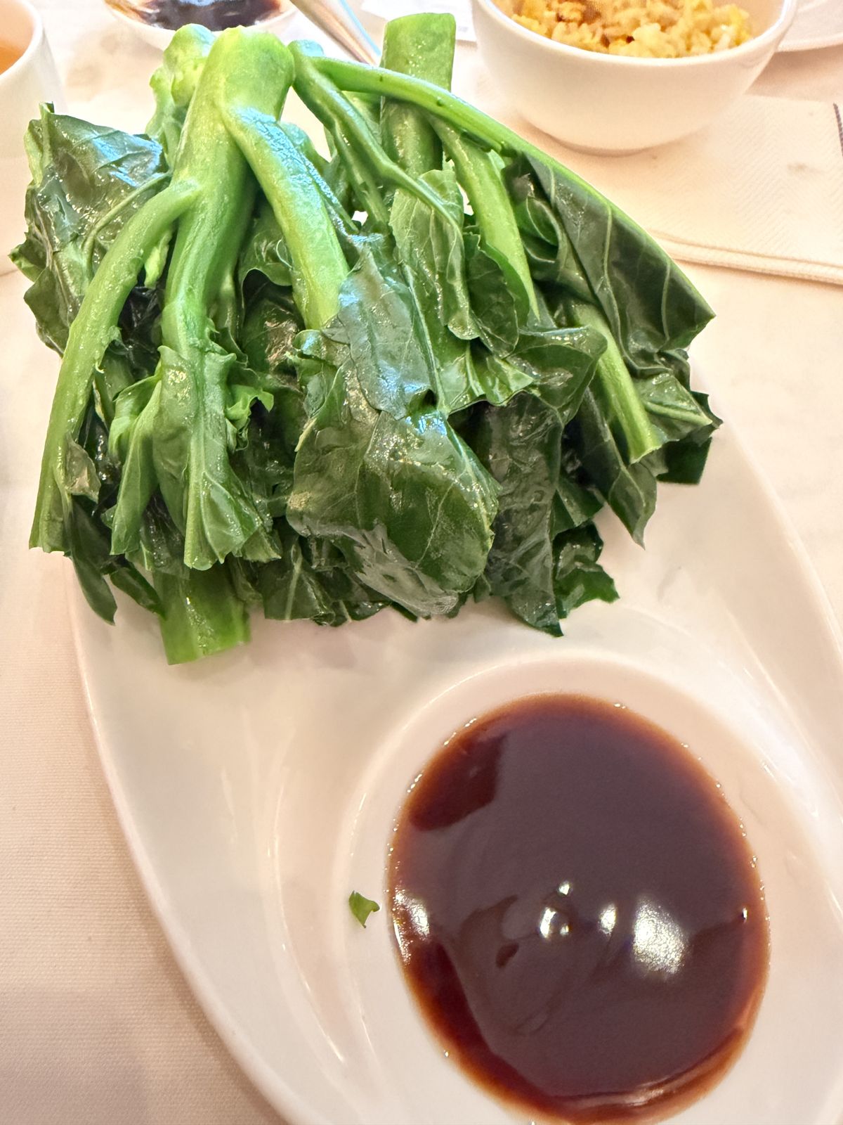 Steamed Chinese broccoli with brown sauce, fried rice behind at HK Lounge Bistro