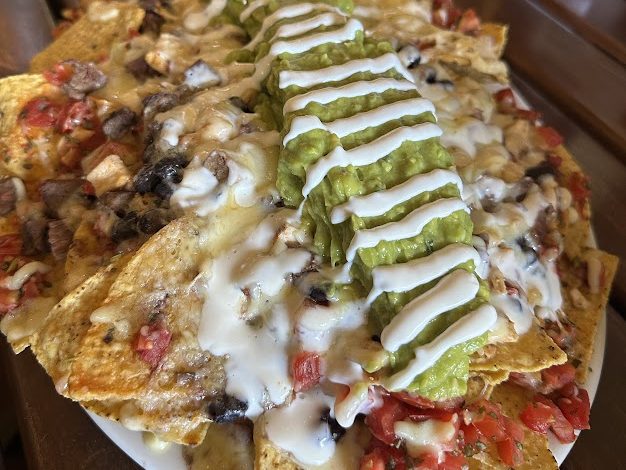 Nachos with a stripe of guacamole, crema and pico de gallo